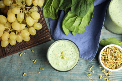 Photo of Flat lay composition with green buckwheat smoothie on light blue wooden table