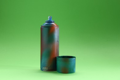 Photo of Spray paint can with cap on green background