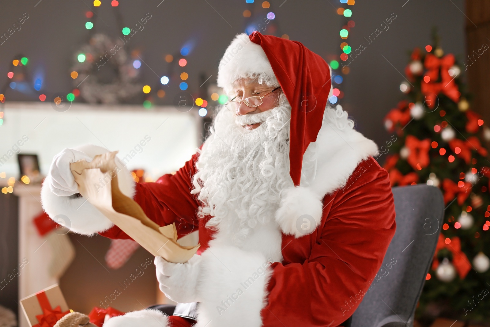 Photo of Authentic Santa Claus reading wish list indoors