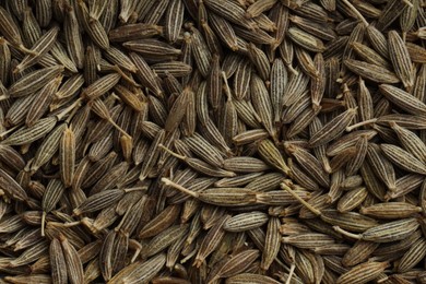 Aromatic caraway seeds as background, top view