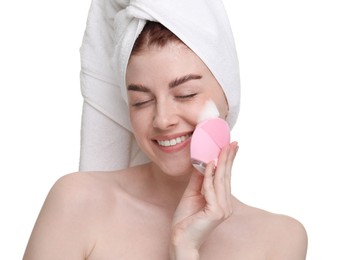 Young woman washing face with brush and cleansing foam on white background