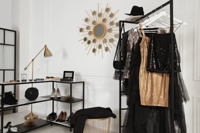 Rack with stylish women's clothes and accessories in dressing room