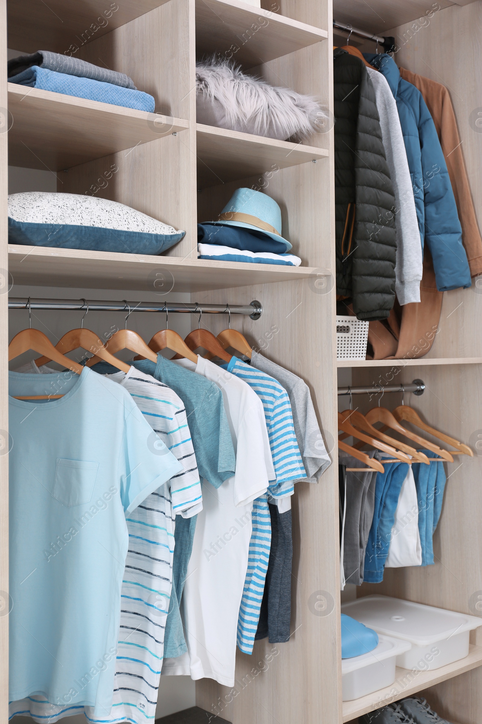 Photo of Stylish clothes and home stuff in large wardrobe closet