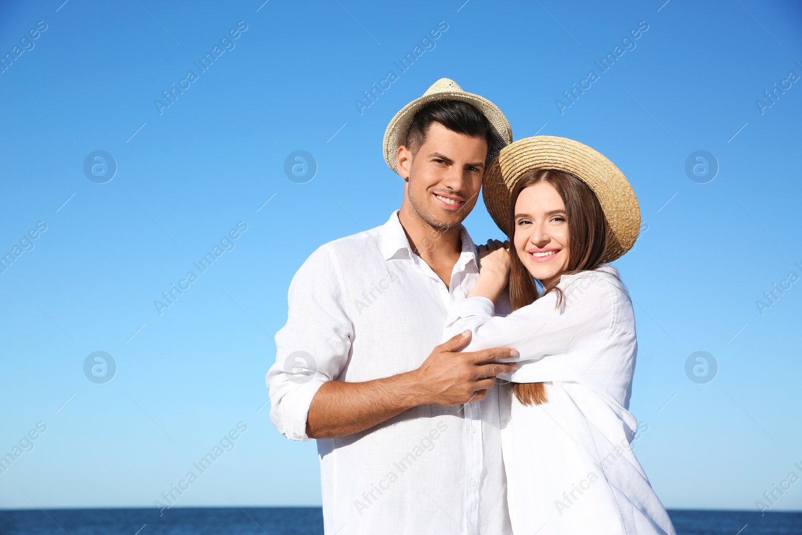 Photo of Lovely couple wearing hats together on beach