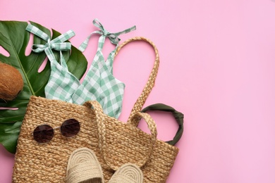 Photo of Flat lay composition with woman's straw bag on pink background. Space for text