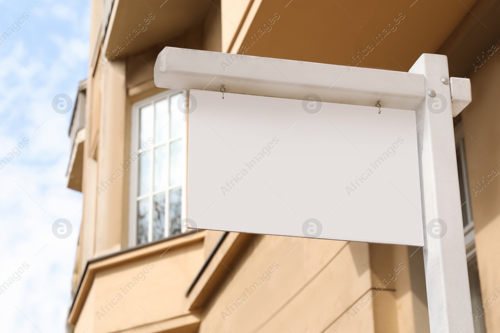 Photo of Blank advertising board on city street, low angle view. Mockup for design