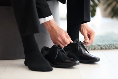 Photo of Young man trying on shoes in store