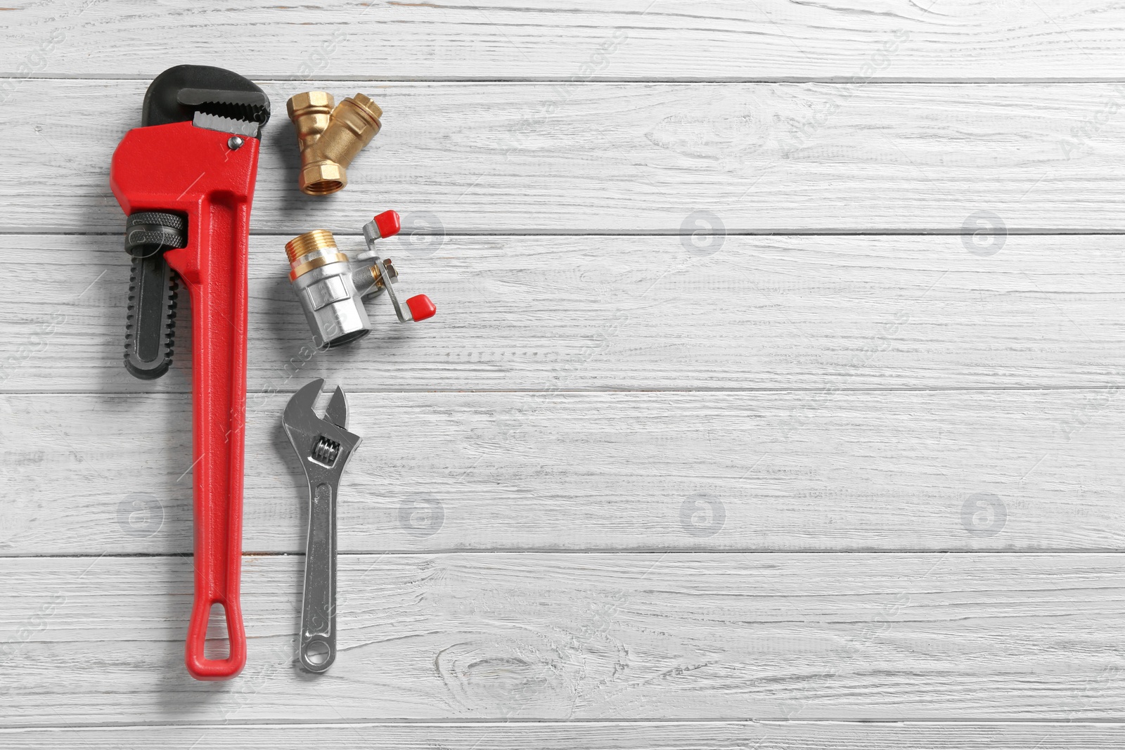 Photo of Flat lay composition with plumber's tools and space for text on wooden background