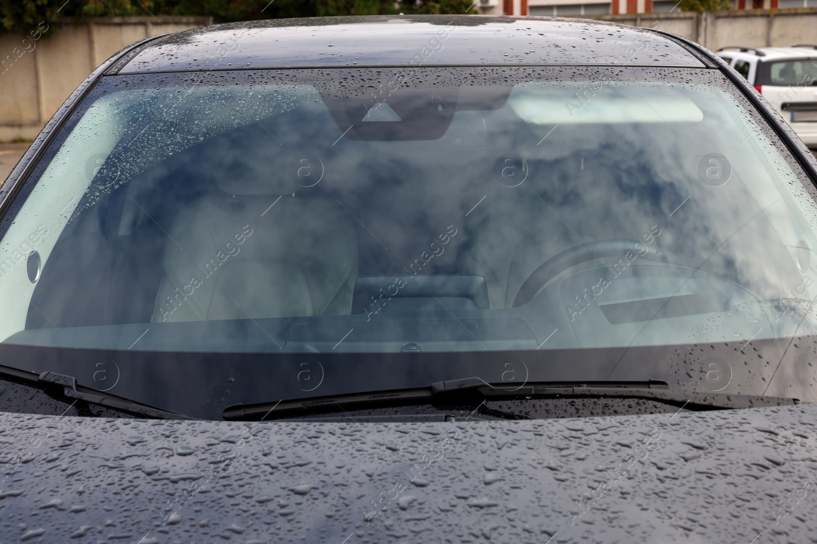 Photo of Car wipers cleaning water drops from windshield glass, closeup