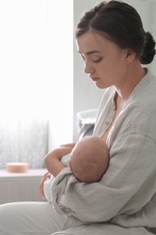 Mother holding her sleeping baby at home