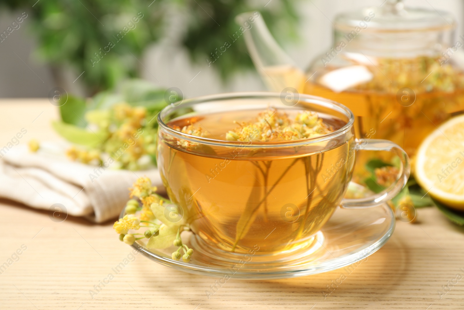 Photo of Cup of tea with linden blossom on wooden table