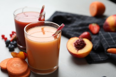 Delicious juices and fresh ingredients on grey table, closeup. Space for text