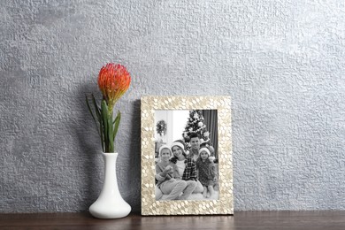 Image of Black and white Christmas portrait of family in photo frame on table near grey wall