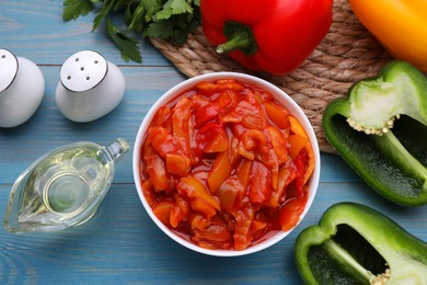 Photo of Delicious lecho and ingredients on light blue wooden table, flat lay