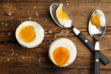 Photo of Tasty boiled chicken eggs on wooden table, flat lay