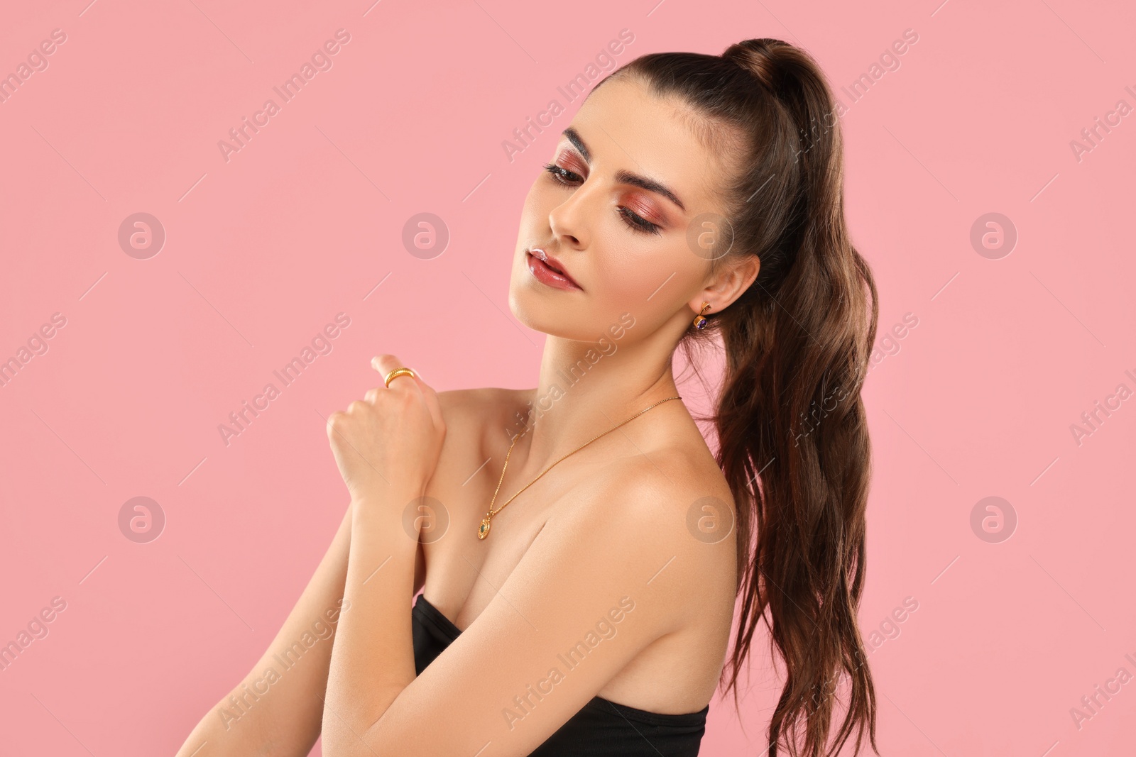 Photo of Beautiful woman with elegant jewelry on pink background