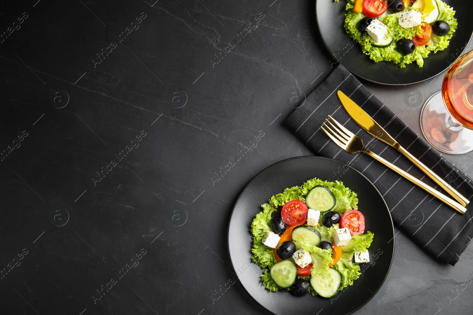 Photo of Tasty fresh Greek salad on dark table, flat lay. Space for text