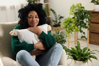 Photo of Woman relaxing near beautiful houseplants at home. Space for text