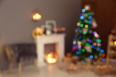 Photo of Blurred stylish room interior with Christmas tree and decorative fireplace