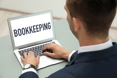 Image of Bookkeeping concept. Man working with laptop at grey table, closeup