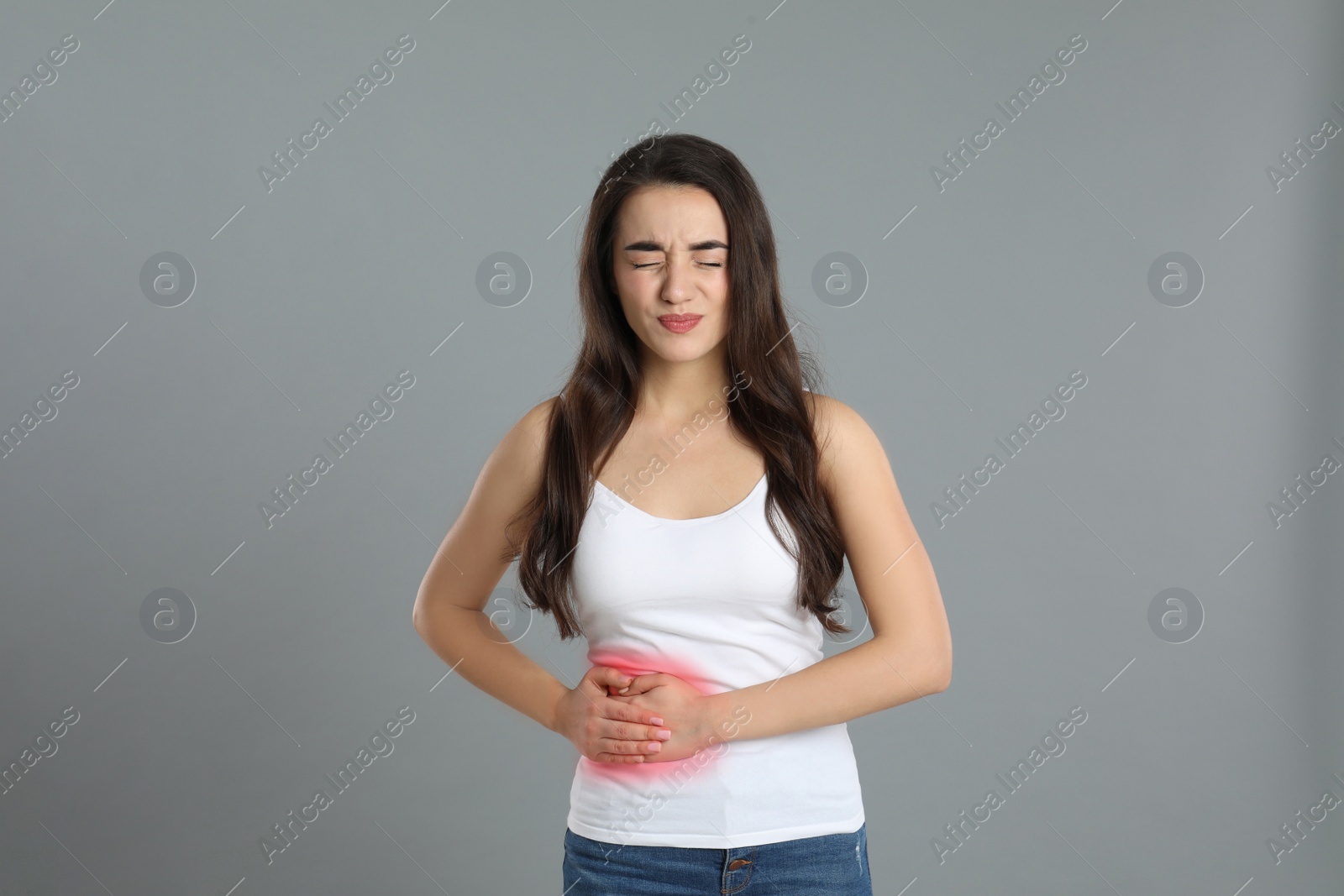 Photo of Young woman suffering from liver pain on grey background