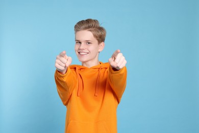 Photo of Portrait of smiling teenage boy on light blue background