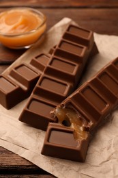 Photo of Tasty chocolate bars on wooden table, closeup