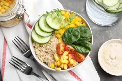 Photo of Healthy quinoa salad with vegetables in bowl served on table, top view