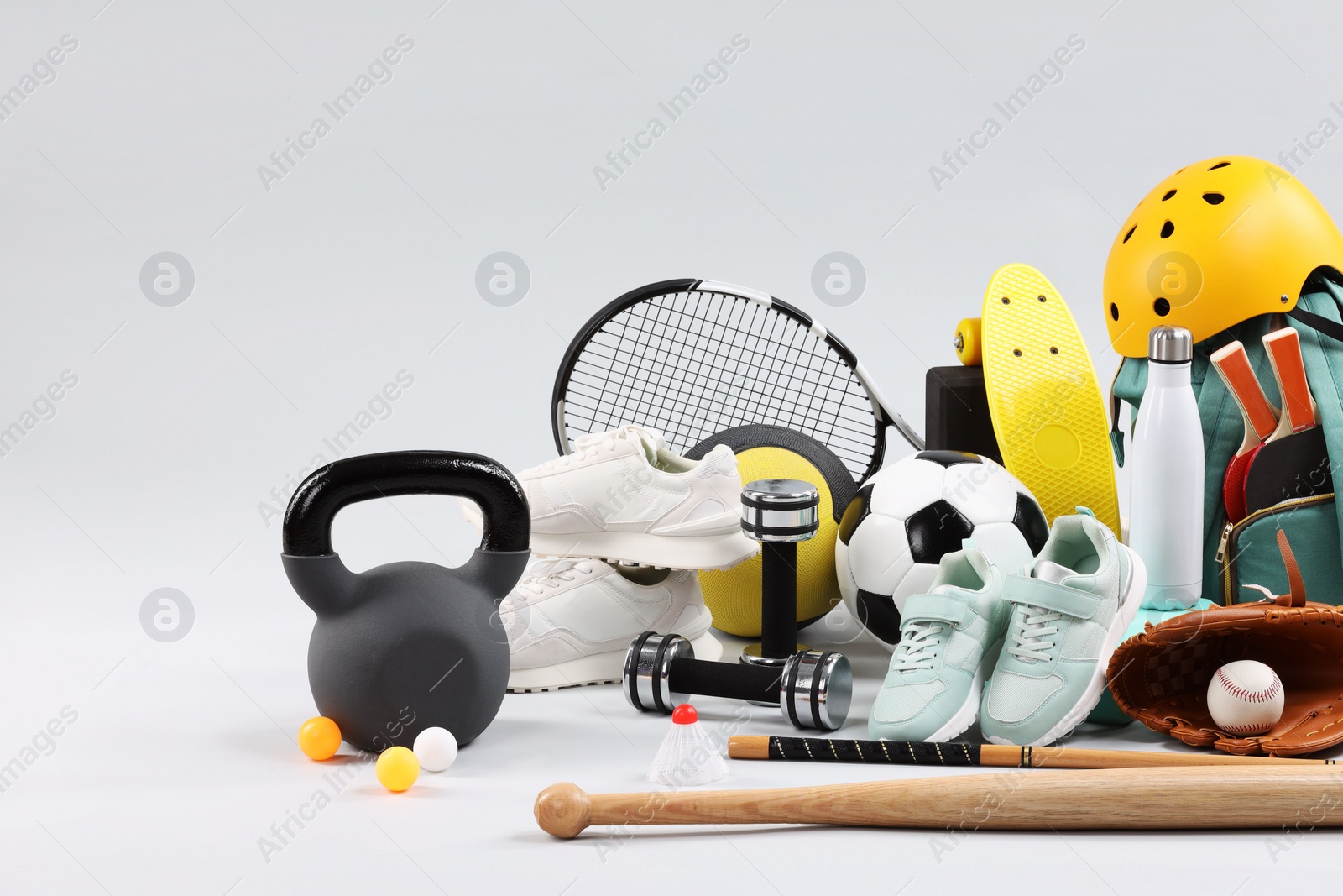 Photo of Many different sports equipment on light grey background