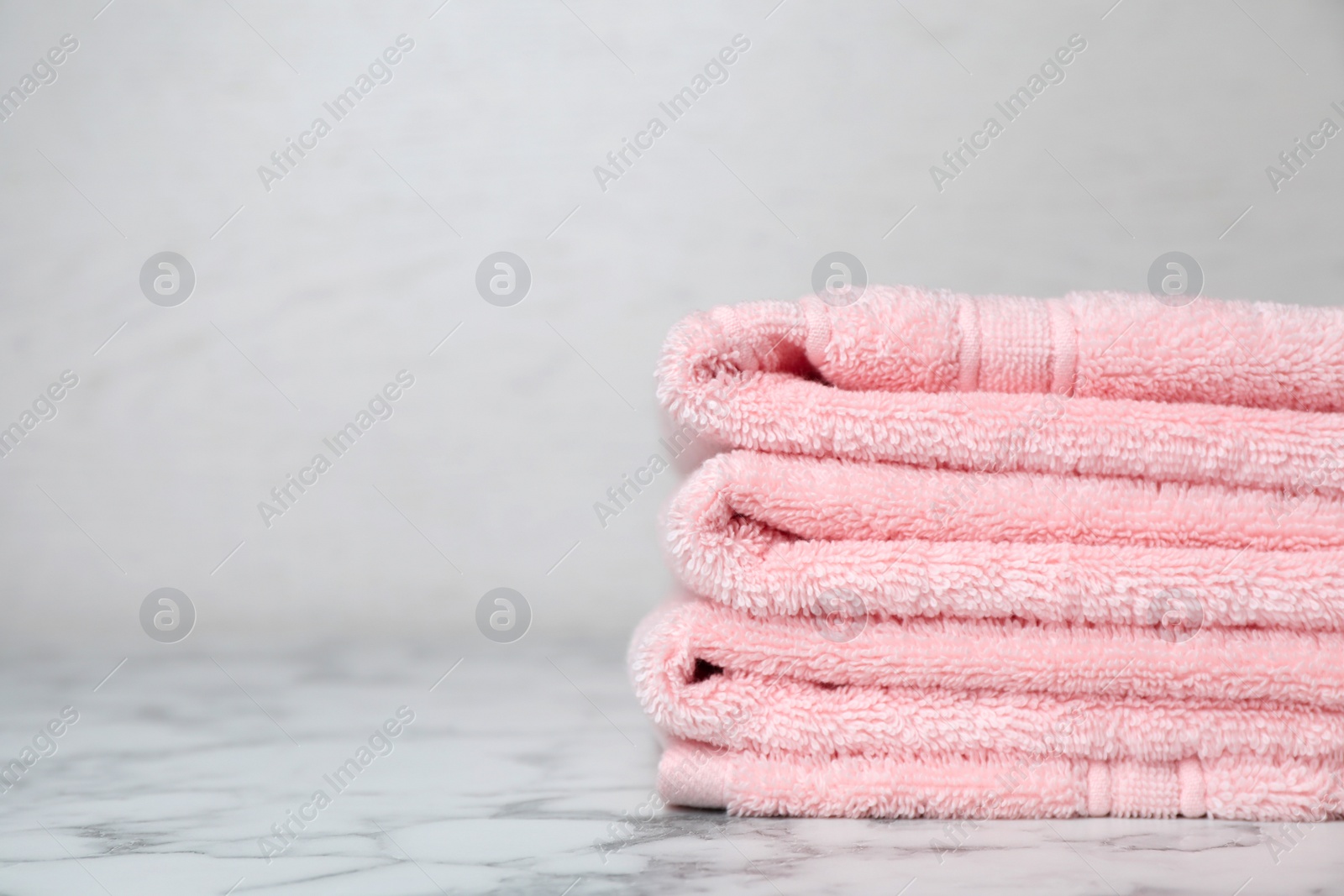 Photo of Stack of soft bath towels on table. Space for text