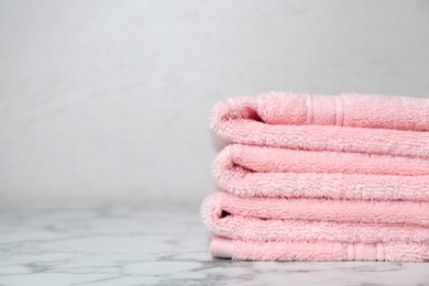 Photo of Stack of soft bath towels on table. Space for text