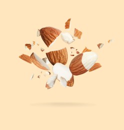Image of Pieces of tasty almonds falling on beige background