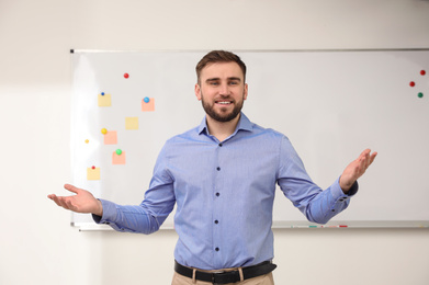 Portrait of young teacher near whiteboard in classroom