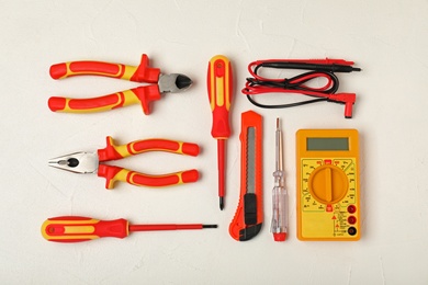 Photo of Flat lay composition with electrician's tools on light background