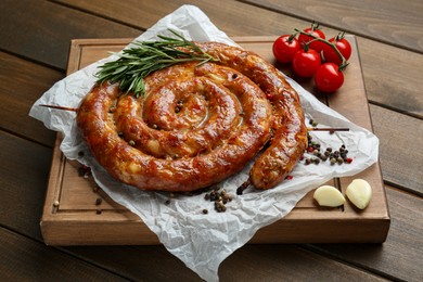 Delicious homemade sausages with spices and tomatoes on wooden table