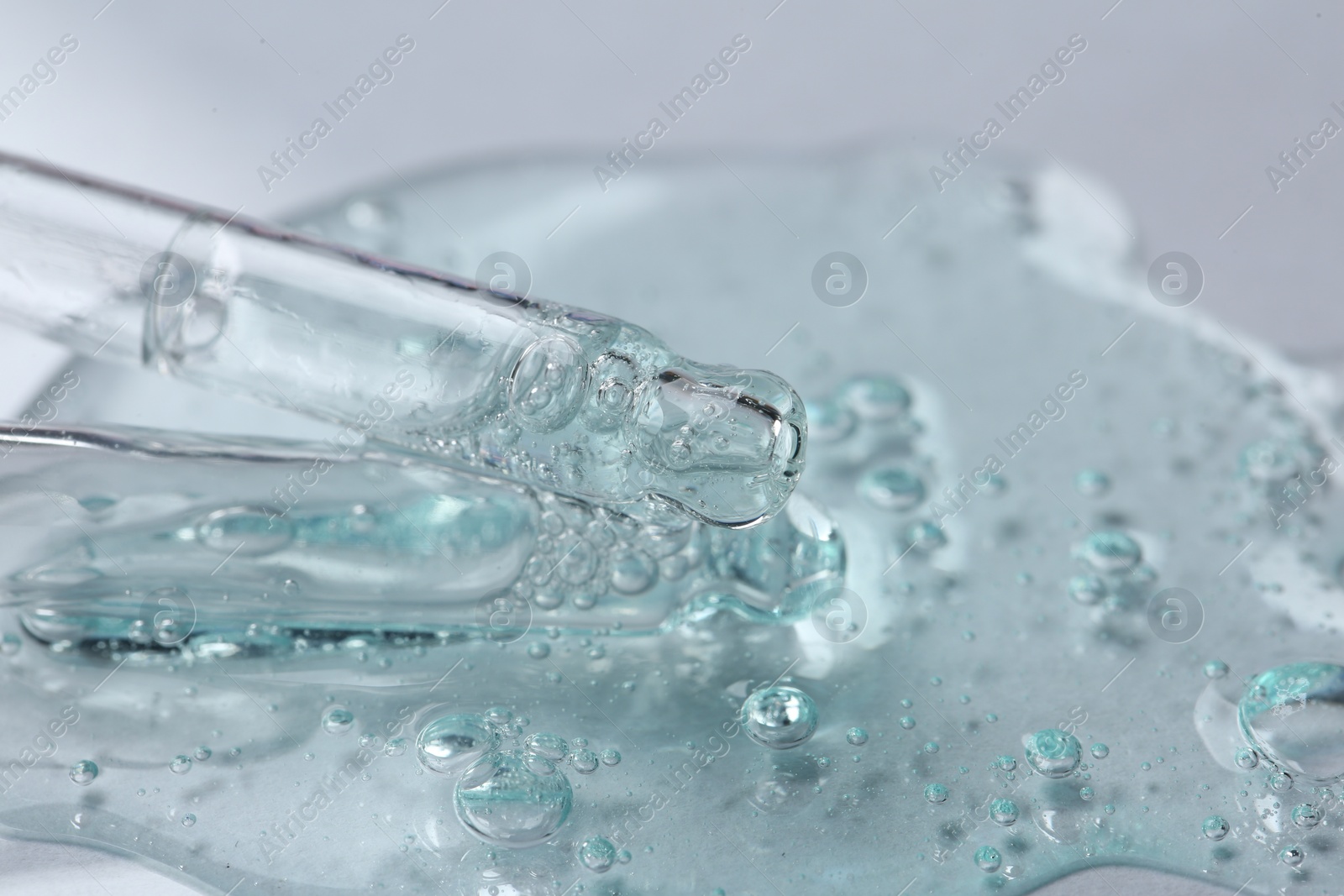 Photo of Pipettes with cosmetic serum on white background, closeup. Space for text