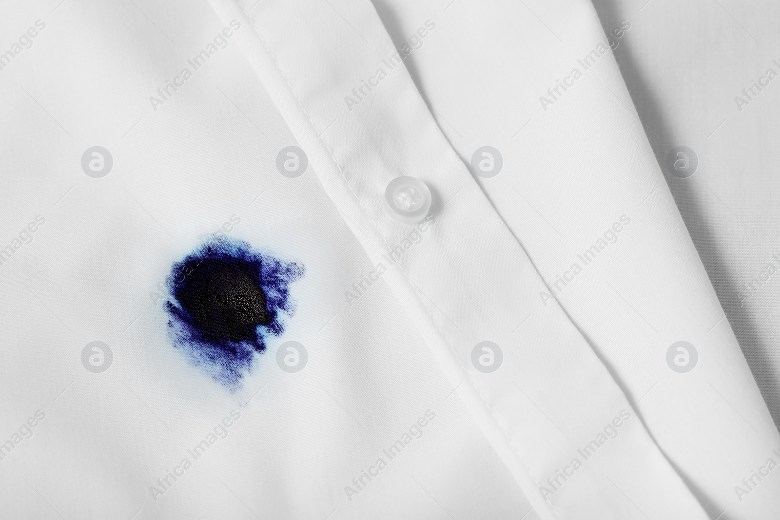 Photo of Stain of blue ink on white shirt, top view. Space for text