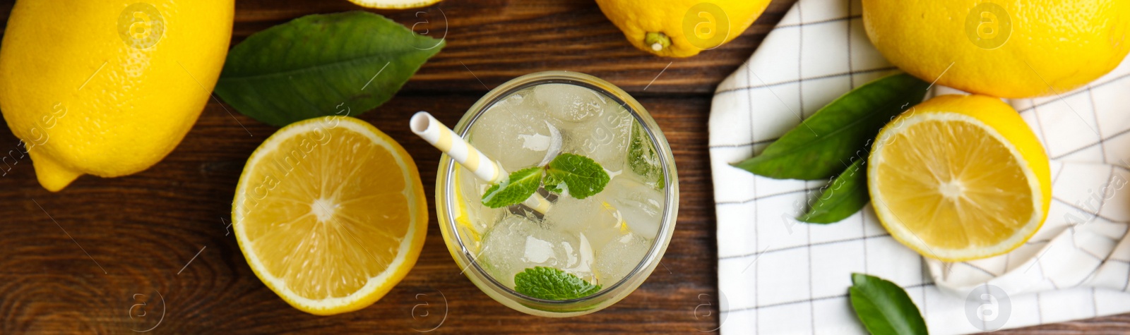 Image of Cool freshly made lemonade and fruits on wooden table, flat lay with space for text. Banner design