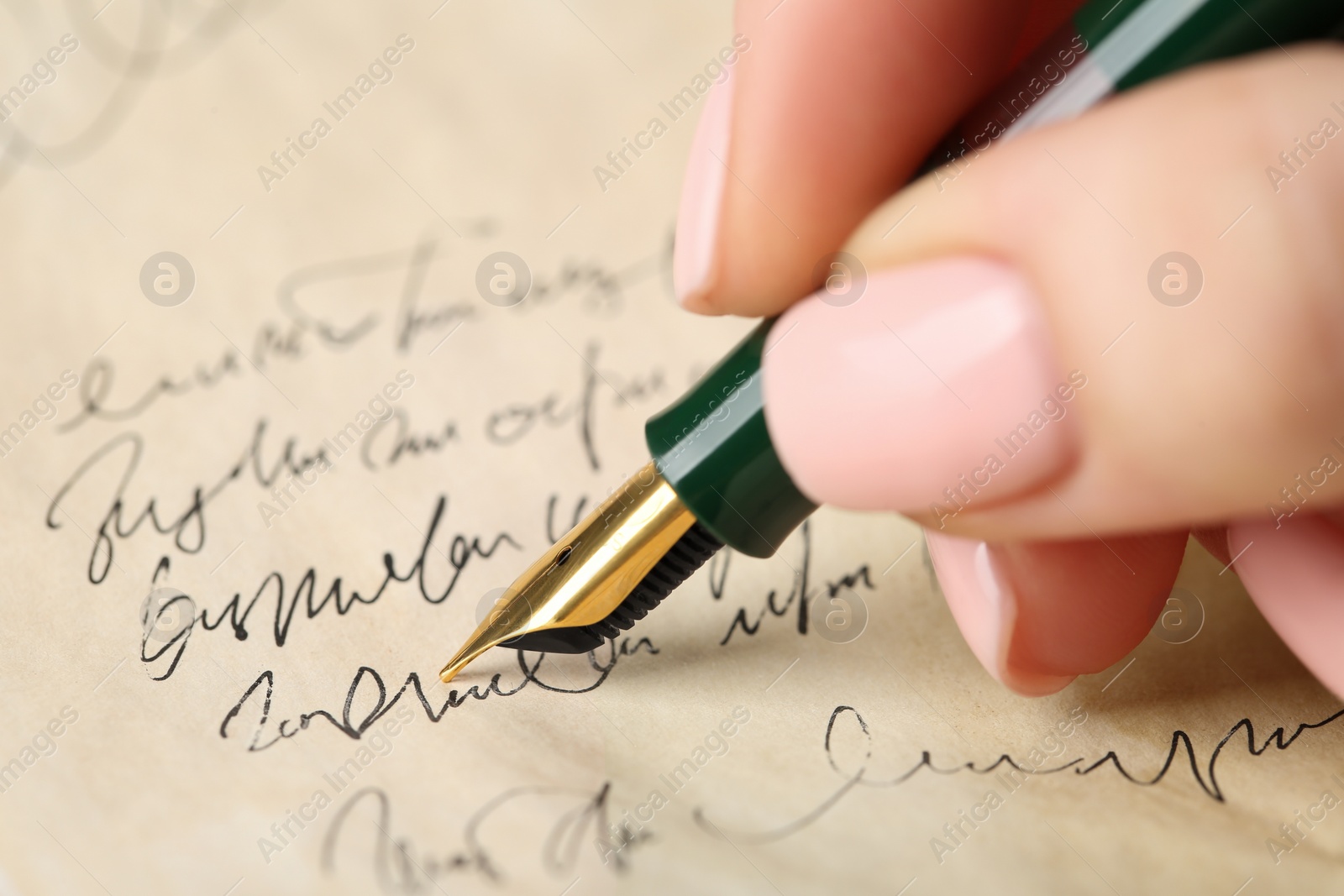 Photo of Woman writing letter with fountain pen, closeup