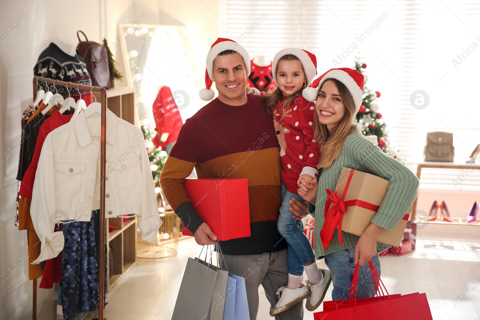 Photo of Happy family with Santa hats doing Christmas shopping in store