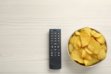 Photo of Modern tv remote control and chips on white wooden table, flat lay. Space for text
