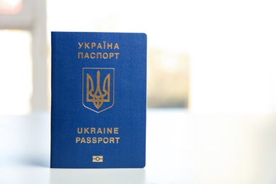 Ukrainian travel passport on table against blurred background, space for text. International relationships