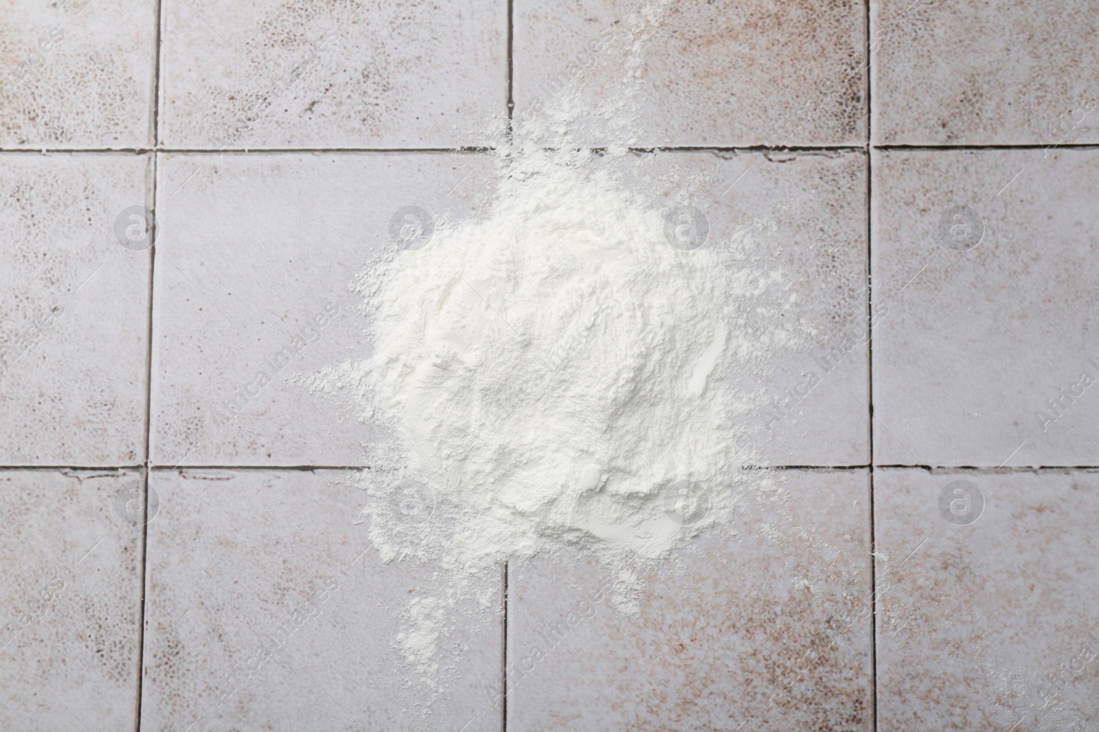 Photo of Pile of baking powder on light tiled table, top view