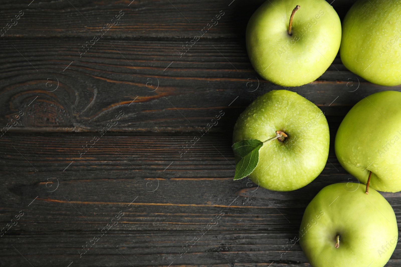 Photo of Flat lay composition of fresh ripe green apples on black wooden table, space for text