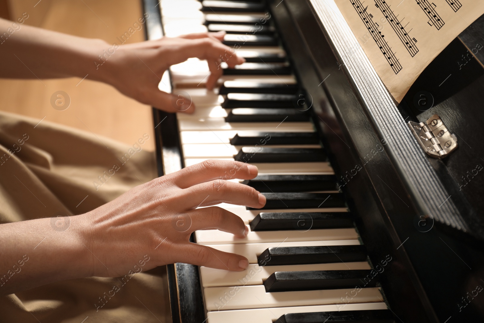 Photo of Young woman playing piano, closeup. Music lesson