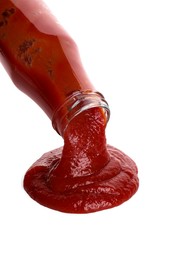 Photo of Pouring tasty ketchup from bottle isolated on white. Tomato sauce