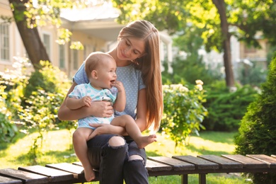 Photo of Teen nanny with cute baby outdoors on sunny day