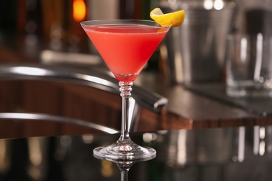 Photo of Cosmopolitan cocktail on black table in bar