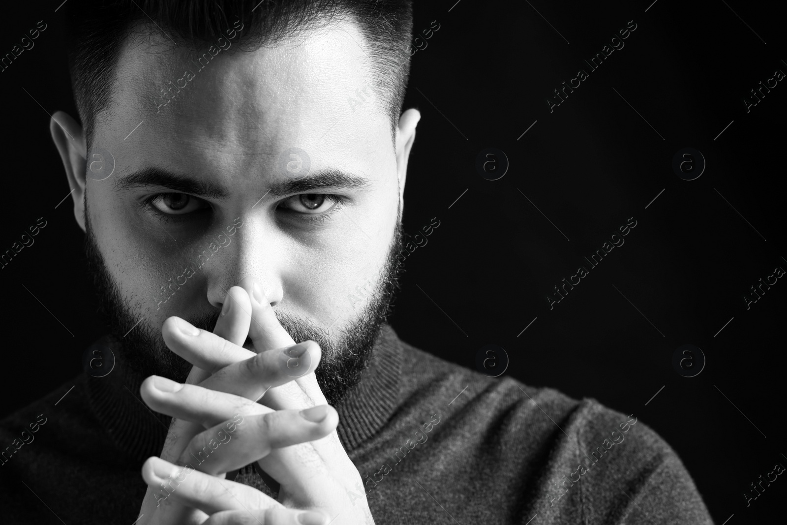 Photo of Portrait of handsome bearded man on dark background. Black and white effect