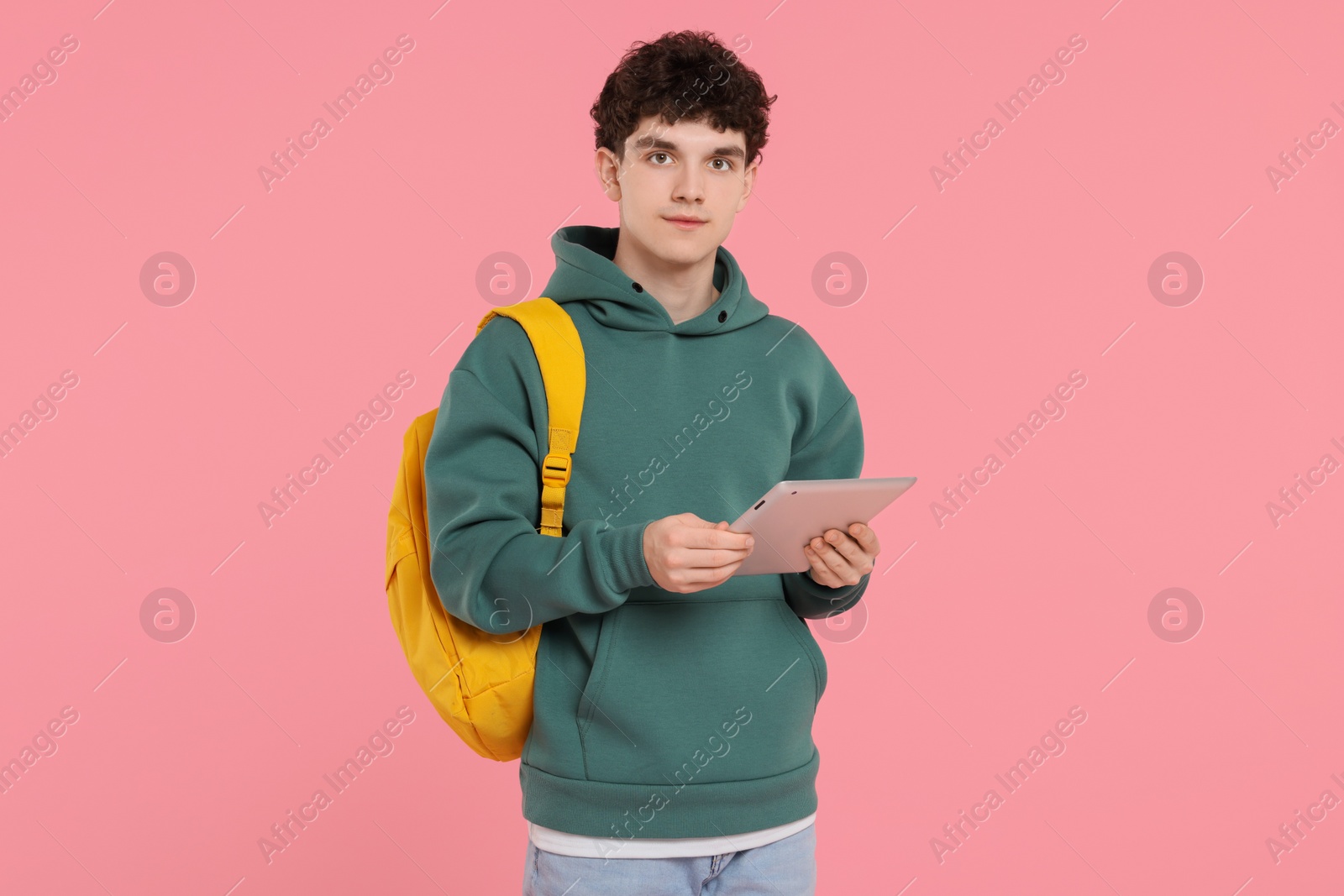 Photo of Portrait of student with backpack and tablet on pink background